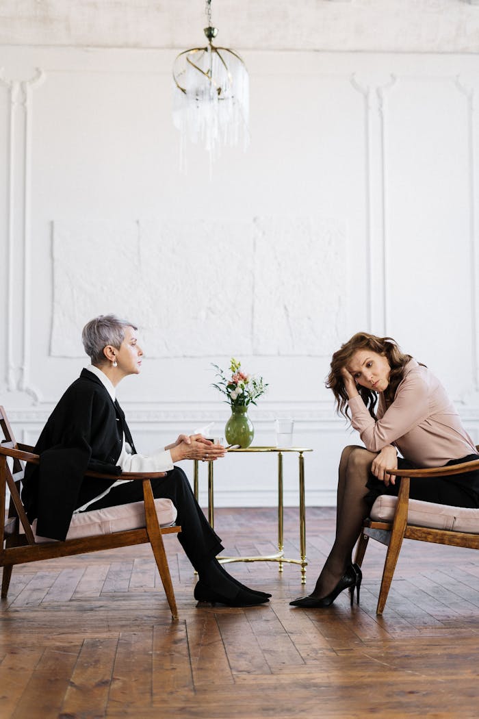 about-01 Two women engaged in a counseling session, discussing mental health indoors.
